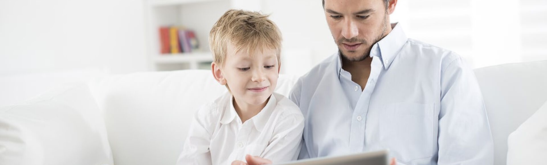 Padre e hijo juegan en el iPad